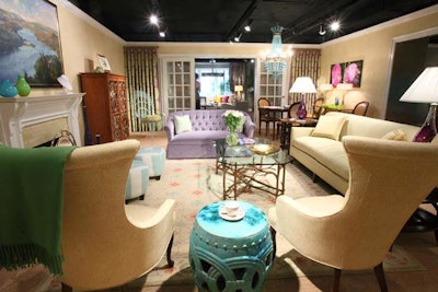 Susan Nelson created a jewel-toned living room to match Dina Mackney’s necklace, drawing turquoise, coral, yellow, and lavender accent colors from the Asmara rug. Nelson incorporated a tufted lavender love seat, aqua chandelier, and aqua “peacock” chairs.