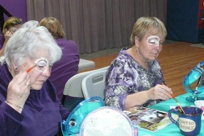 Attendees get in the cirque spirit with a makeup application lesson.