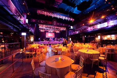 Tables covered with gold and red linens filled the first-floor space; cocktail tables lined the perimeter of the second floor.