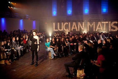 A marquee spelled out Lucian Matis's name in lights, and the crowd was seated on the wooden floor, right in the middle of the runway show.
