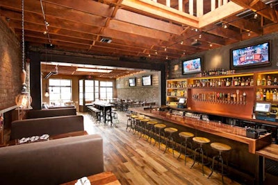 The 2,400-square-foot bar and restaurant has distressed brick walls; exposed wooden beams; industrial, Edison-inspired bulbs; reclaimed wood floors; and a digital jukebox.