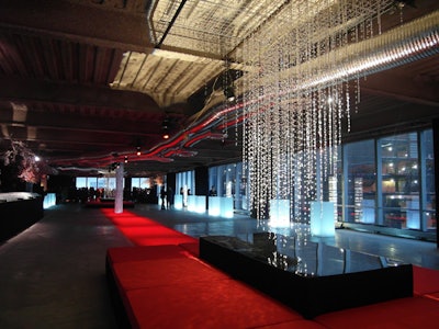 To create a budget-conscious look that carried throughout the cocktail area, Baura New York extended a red carpet from the event's entrance and ran it down the middle of the space.