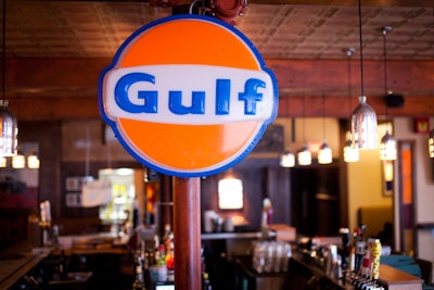 Vintage decor includes a Gulf sign and a collection of seltzer bottles.