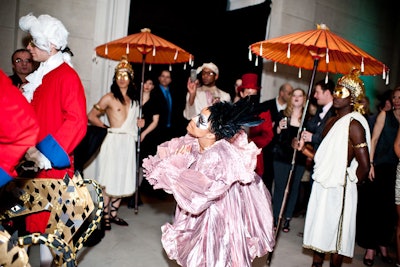 The Marchesa's flamboyant procession included puppets, parasols, and masked figures.