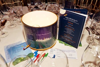 The dinner table centerpieces, which could be rotated using an attached pencil nub, featured quotes from the nonprofit's business partners, principals, students, and parents. To allow guests to note their bids for the JetBlue auction, the event's organizers supplied plane-ticket-style cards at each table.