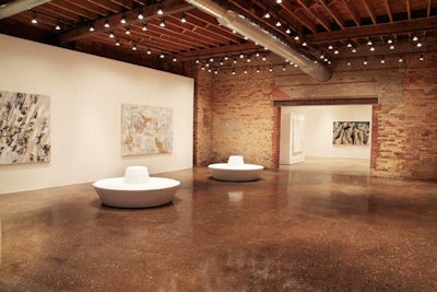 Polished concrete floors and high wooden-beam ceilings accent the gallery.