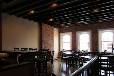 The second floor of Bookhill Bistro features exposed brick wall details and exposed panel ceilings.
