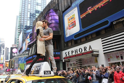 At around 11 a.m., models Anja Rubik and Sasha Knezevic recreated the pose for the fragrance's ad campaign by kissing atop a taxi.