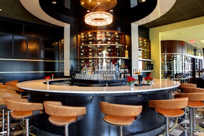 The bar area has cognac-colored seats and a round shape.