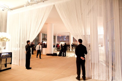 To divide the east and west lobbies, the design team used a white fringe curtain. The textural drape was also used as a backdrop for the 24-foot mirrored bar that anchored the western side of the site.