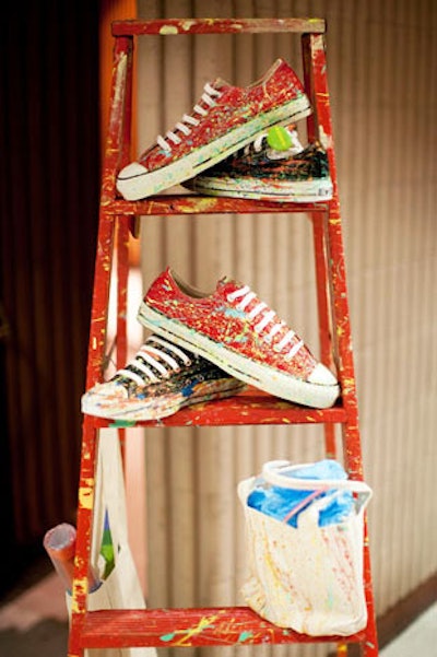 Painted items available for purchase, including sneakers and bags, doubled as decor set on ladders.