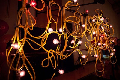 Sculptural lighting made from materials like extension cords and hula hoops lit the large gymnasium where dinner took place.