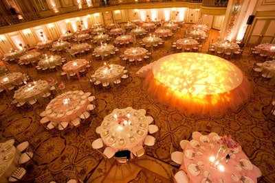 At the center of the ballroom, an illuminated stage had a tutu-like ruffle around its rim. Four violinists performed on the balletic structure.