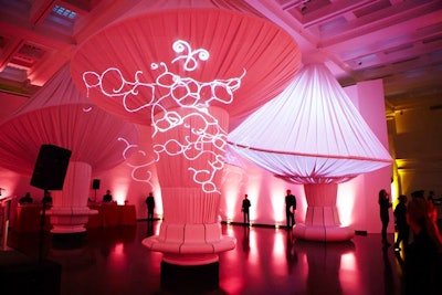 Installed around the space's existing columns, Situ Studio's mushroom-shaped structures were lit from within and projections on the exterior helped create a fanciful look for the reception.