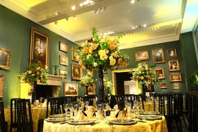 The bright yellow linens and black chairs contrasted with the green walls in a first-floor gallery.