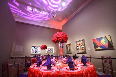 Purple, flower-shaped projections on the ceiling complemented the red and purple table settings in one gallery.