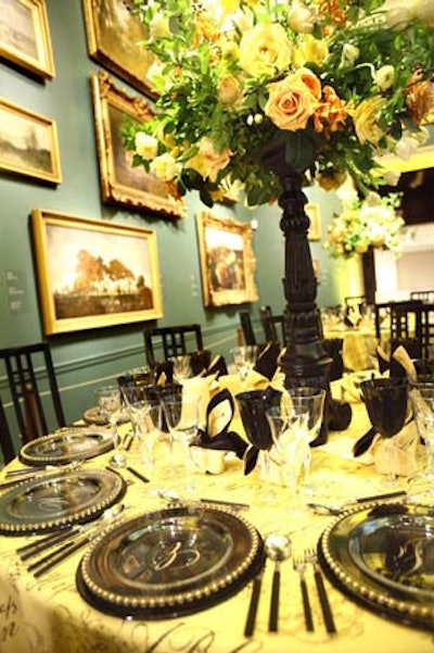 Black chargers, napkins, and wineglasses topped yellow linens in one of the galleries.