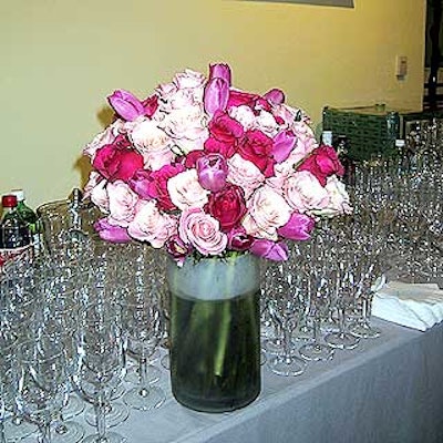 Mood Food decorated tables with bouquets of pink and violet roses in clear cylindical vases.