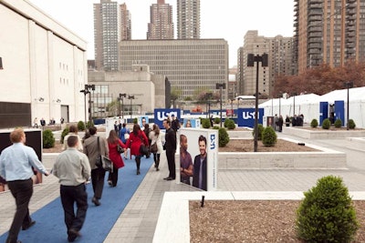 A blue carpet and USA signage point guests in the direction of the upfront's tented venue.