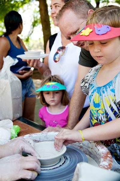 Super Awesome Cool Pottery promoted its summer camp classes by setting up a pottery wheel for kids to try.