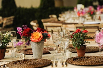 For the dinner, the organizers created 82 natural wood tables with tree-trunk bases and set crystal, china, and silver pieces on the bare tabletops. The centerpieces comprised peonies, roses, jasmine, and lilacs in aged terra-cotta pots.