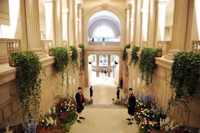 To guide guests from the great hall to the Iris and B. Gerald Cantor Exhibition Hall, where 'Alexander McQueen: Savage Beauty' is on view, Raúl Àvila lined the museum's grand staircase with lavender, heather, cascading English roses, and ivy.