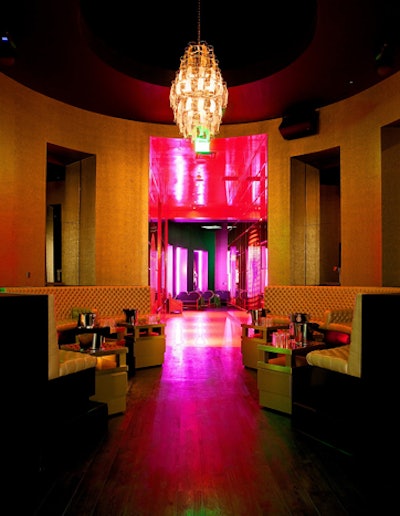 Curvilinear golden booths and opulent chandeliers deck the space.