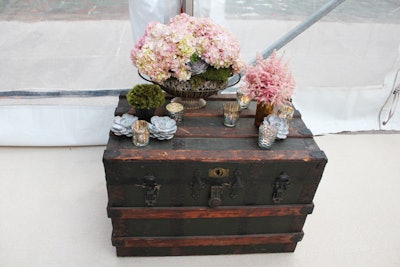 Rather than tables, the event had weathered trunks topped with antique-style votives and vases.