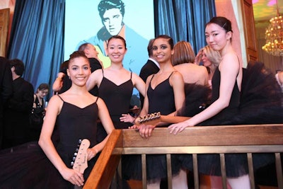 Ballerinas in black leotards holding guitars lined the main staircase as guests arrived.