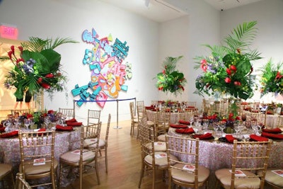 Jacky Lucky designed oversize centerpieces with palm fronds accented by red and purple flowers to complement the dotted table linens in one gallery.