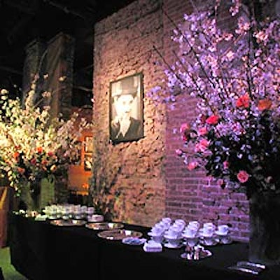 A dessert table was decorated with large arrangements with apple blossom branches and roses, and a photograph of Charlie Chaplin. (Photo courtesy of Levy Lighting)