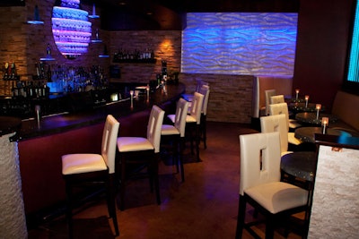 The bar and high-top tables have a subtle glow from fiber-optic lights embedded in the concrete tops.