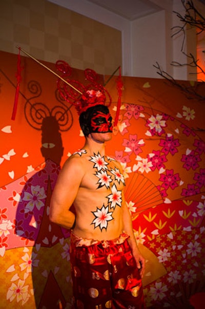 Painted models posed against flowery backdrops in the hallway leading to the event.