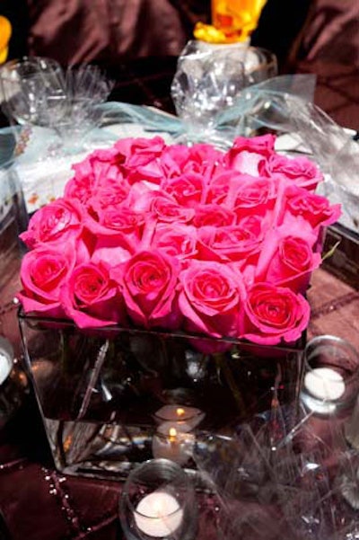 Centerpieces included a mix of tall cylindrical vases and low cubes, both filled with roses.