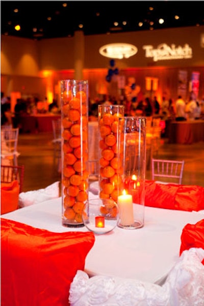 Decorators created simple centerpieces by filling tall cylinders with real oranges.