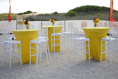 Express Flowers created the centerpieces for the high-top tables draped in bright yellow linens from Prestige Event Services.