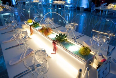 Long, illuminated centerpieces were filled plants that evoked sea creatures.