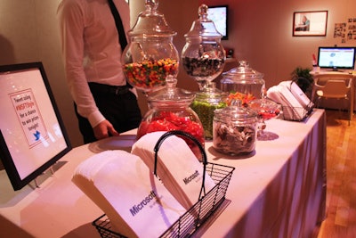 Food and drink were spread throughout the space, including one table that held glass jars of candy and branded bags.