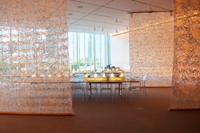 Heffernan Morgan bathed webbed scrims in golden light to cast spiderweblike patterns throughout the dinner space.