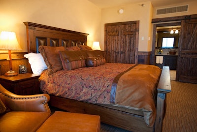 Leather and wood creates a masculine look in the Big Thunder Suite master bedroom.