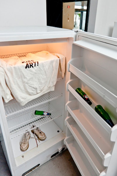 Shoes, a 'Kiss My Art' sweatshirt, and empty bottles of sponsor Kronenbourg filled one of Kikauka's refrigerators.