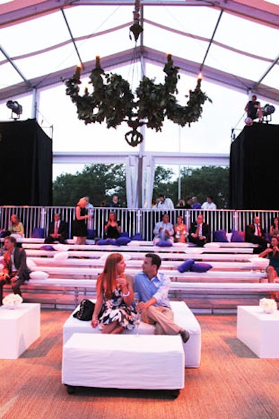 The production crew hung foliage-covered chandeliers from the ceiling of the tent and set up white lounges and padded bleachers with blue and white throw pillows for seating.