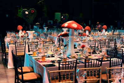 A checkerboard table covering and mismatched gold and silver cutlery added to the mad tea party theme. Mushrooms and heart-shaped hedges were the centrepieces.