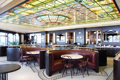 Circular leather booths fill the dining room. Numerous windows and a custom-made stained-glass ceiling illuminate the space.