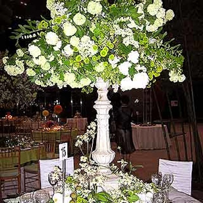 Belle Fleur used a green and white theme with a large arrangement atop a white pedestal and more flowers and some fruit scattered at the base. Each place setting featured a cricket made of bamboo.