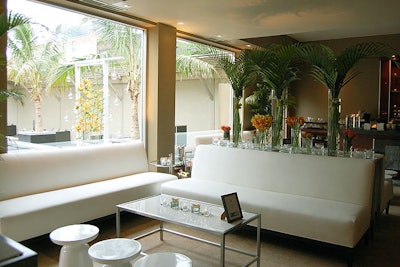 Flower arrangements included orange flowers and palms. White leather furniture played into the Miami-inspired look.