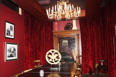 An antique chandelier hangs above a long 25-seat dining table in the semiprivate room at City Fire.