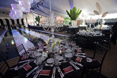 Tabletop decor included white feathers, palm leaves, and crystal candelabras.