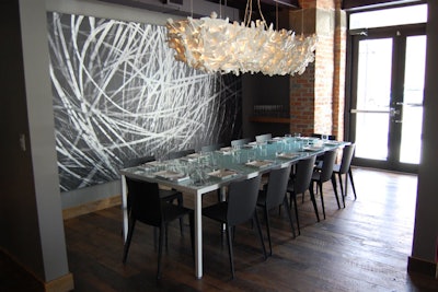 The semiprivate room at Origin seats 14. A whimsical chandelier made from toy monsters hangs above the table.