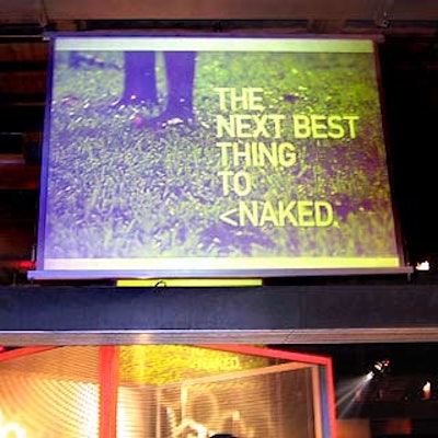 A giant projection screen displayed images from Jockey's current ad campaign. The cube below is a bedroom setup surrounded by window blinds.